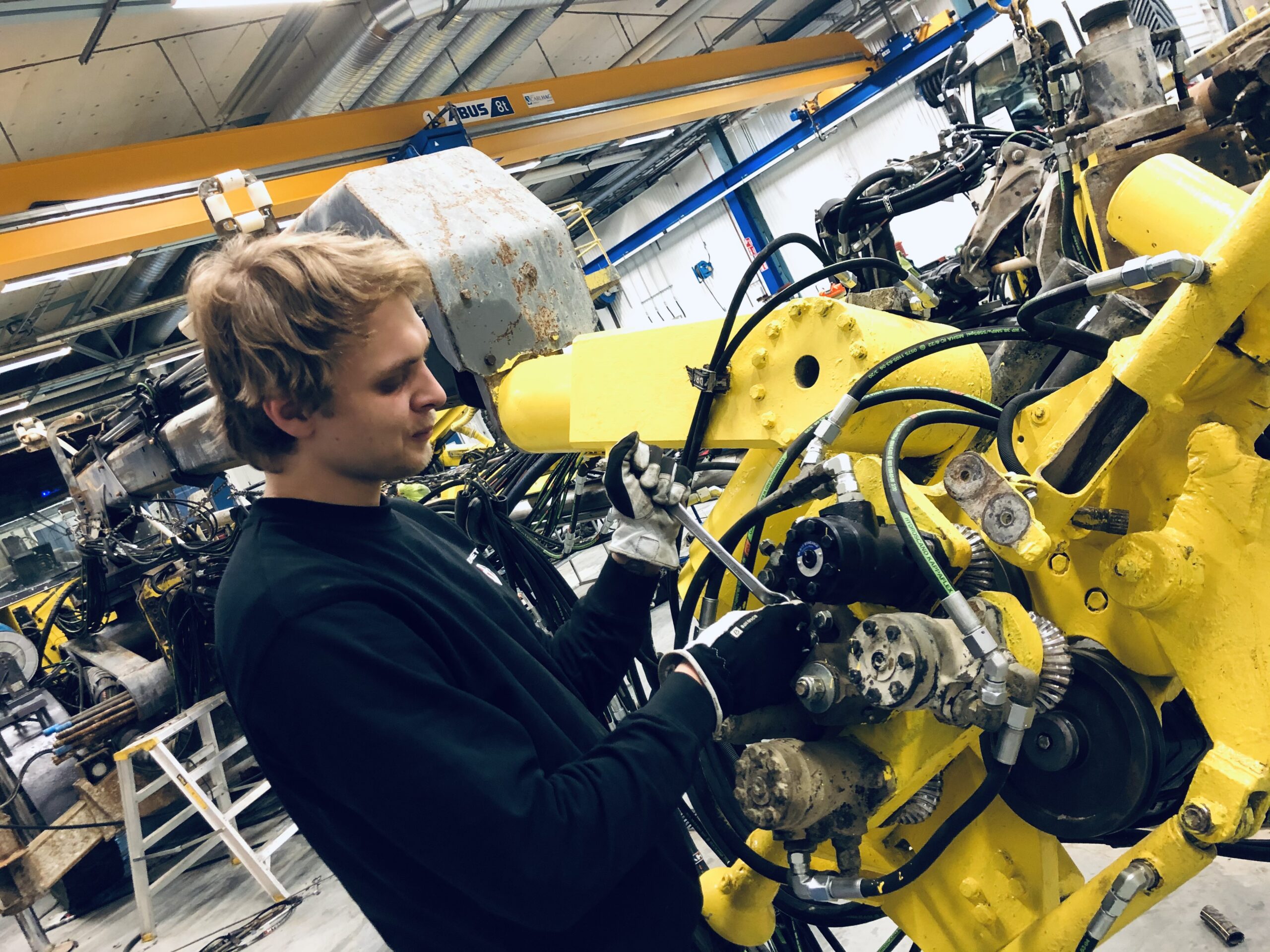 En mekaniker skruvar i gruvmaskin